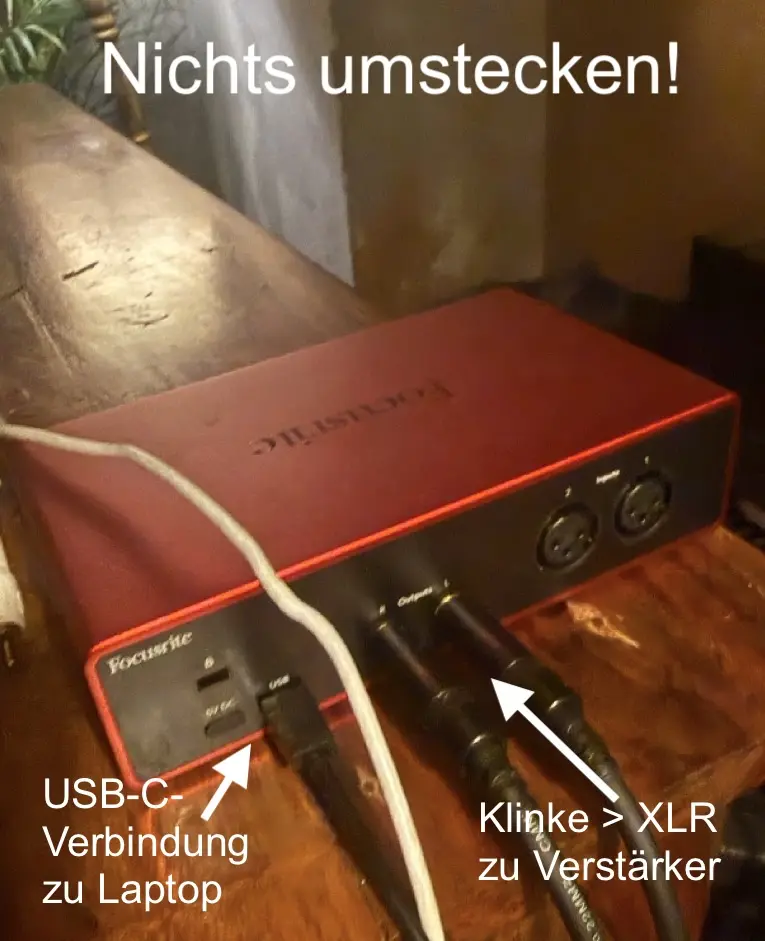 Rückseite des Focusrite-DAC mit beschrifteten Kabeln: USB-C zum Laptop, Klinke auf XLR zum Verstärker. Hinweis im Bild: Nichts umstecken.